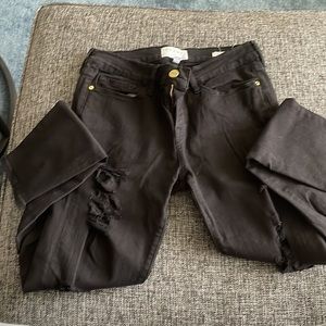 Frame’s Le Skinny de Jeane in black with distressed details on front legs